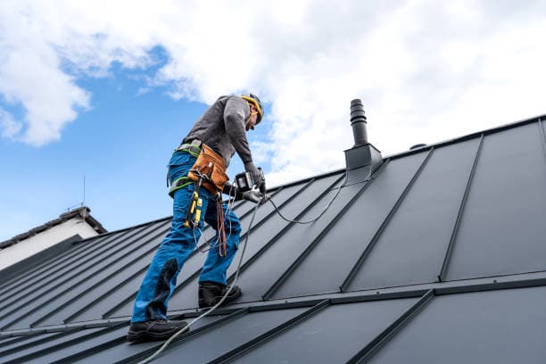 Professional residential roofer at work installing high-quality composite shingles